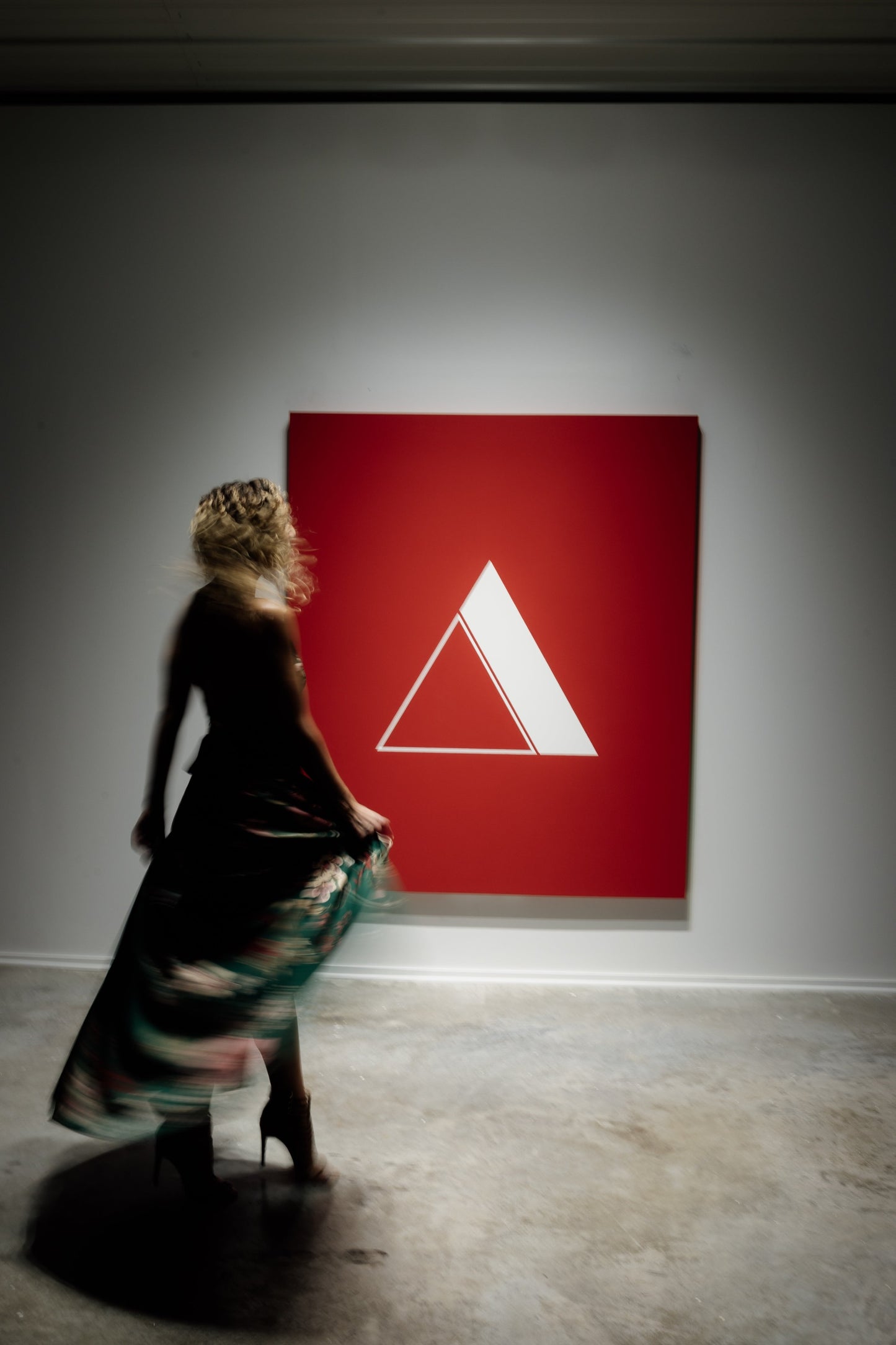 a woman in a dress observing outrun no 2 hanging on a wall